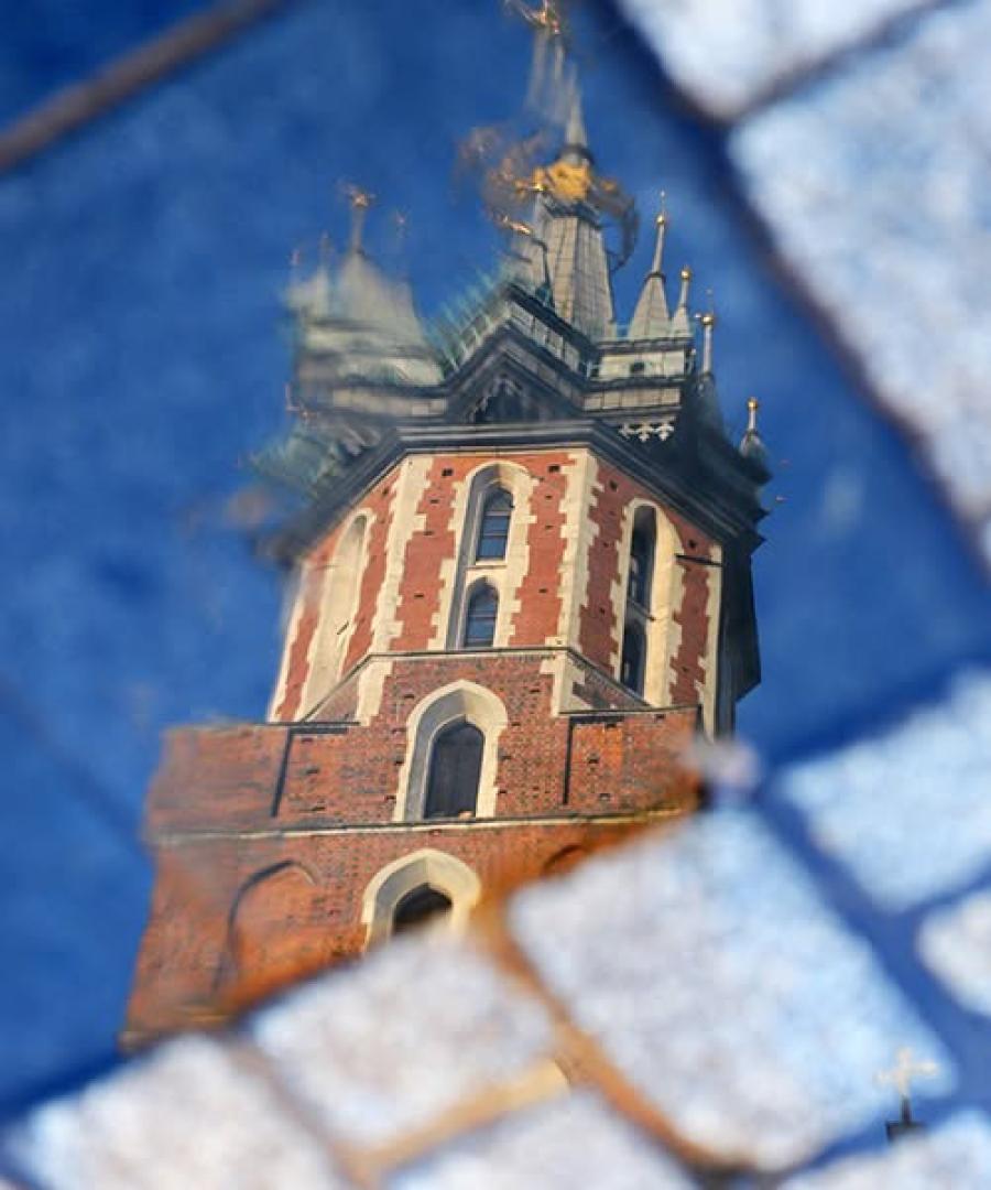 Reflection of St. Mary’s Basilica in a puddle on Krakow’s cobblestone street