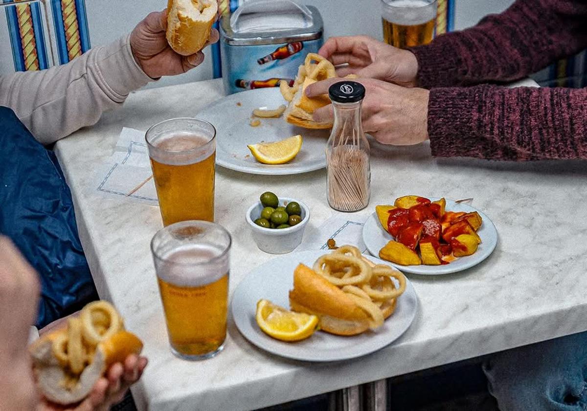 Tapas y bebidas compartidas en una mesa en Madrid